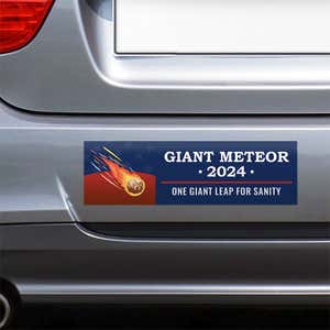 Giant Meteor Bumper Sticker on the bumper of a gray car