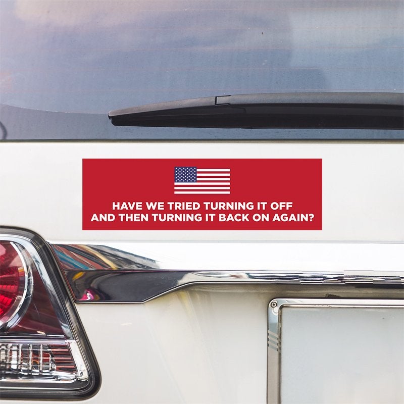 American Flag Funny Political Bumper Sticker above a white car's tail light