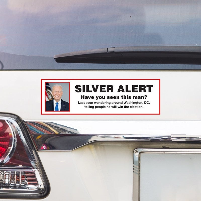 Silver Alert Political Bumper Sticker above a white car's tail light