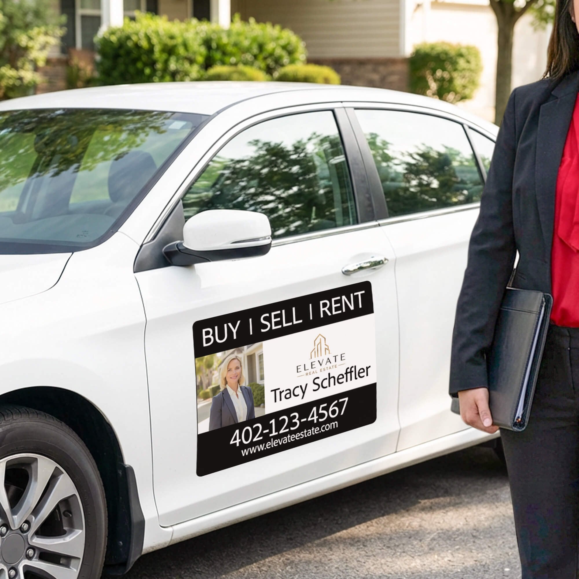 A custom car magnet for a real estate agent on a white car with the agent standing next to the car