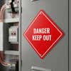 A red diamond aluminum sign by electrical wires with the message DANGER KEEP OUT