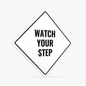 A white diamond aluminum sign with the message WATCH YOUR STEP