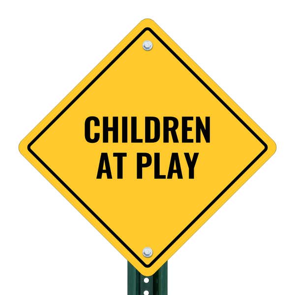 A yellow diamond sign on a post with the message CHILDREN AT PLAY