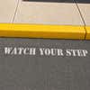Watch Your Step sprayed onto a sidewalk using a stencil