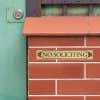 1x6 custom engraved brass sign displayed on brick
