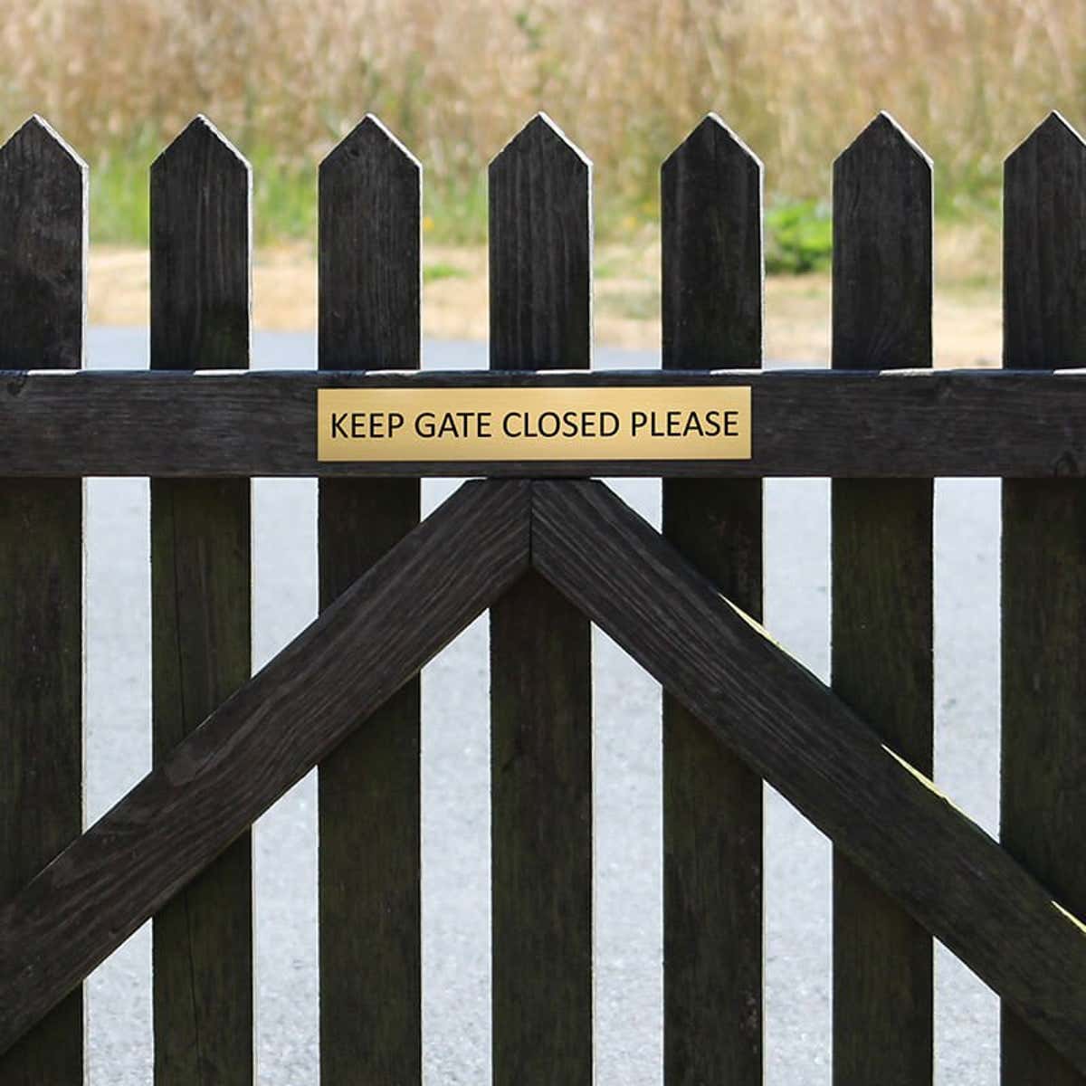 2x12 custom engraved brass sign on a fence