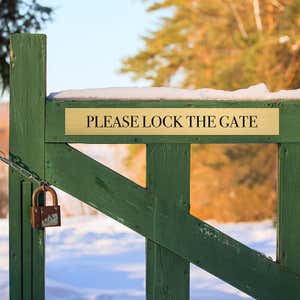 3x24 custom engraved brass sign on a fence