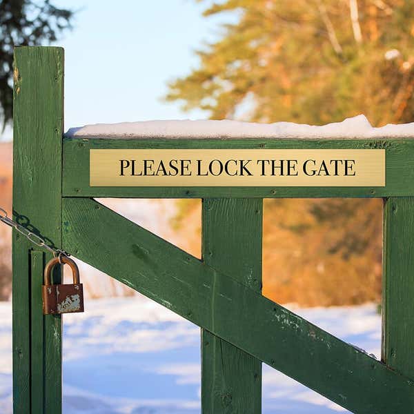 3x24 custom engraved brass sign on a fence