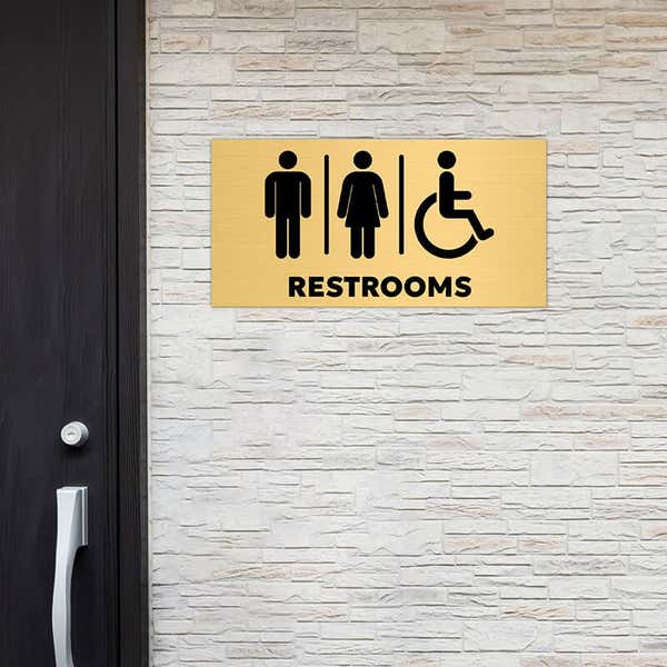 6x12 custom engraved brass sign displayed by a restroom