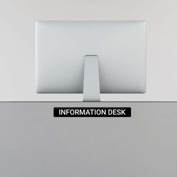 Engraved Sign Horizontal 2" x 16" on an information desk