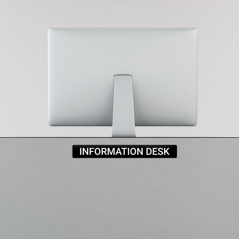 Engraved Sign Horizontal 2" x 16" on an information desk