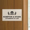 Engraved plastic sign displayed on a wooden wall