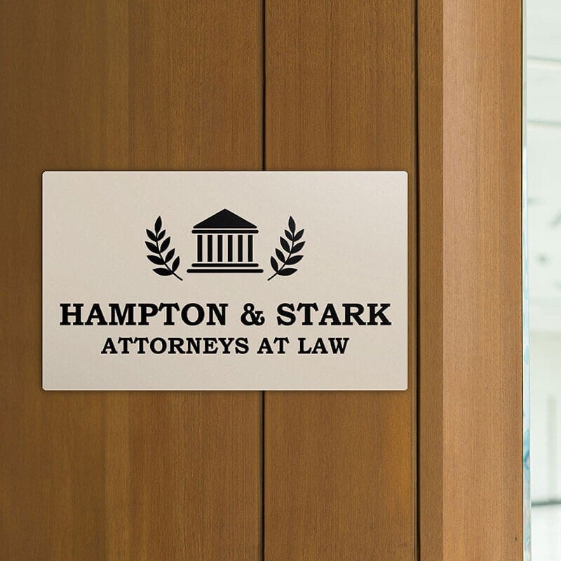 Engraved plastic sign displayed on a wooden wall
