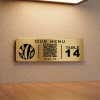 A small gold engraved plastic sign with a QR code for a restaurant menu