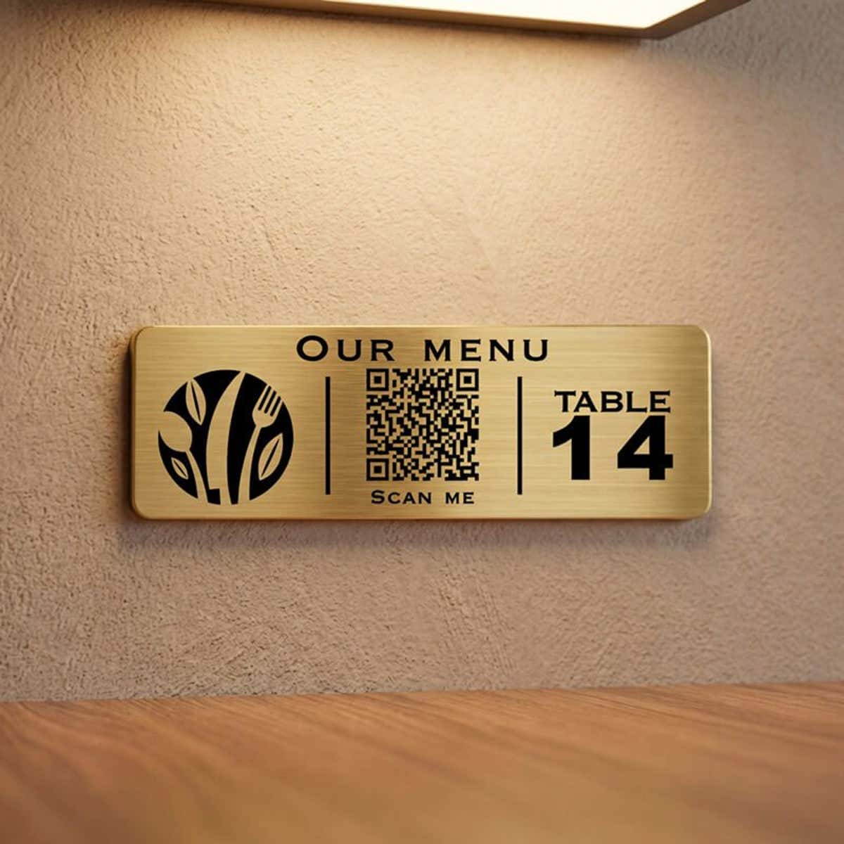A small gold engraved plastic sign with a QR code for a restaurant menu