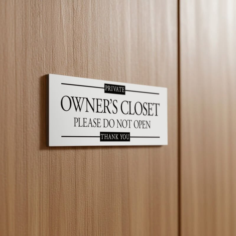 A small plastic sign on a door to label a private closet 