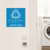 A baby blue engraved plastic sign for a hotel laundry room