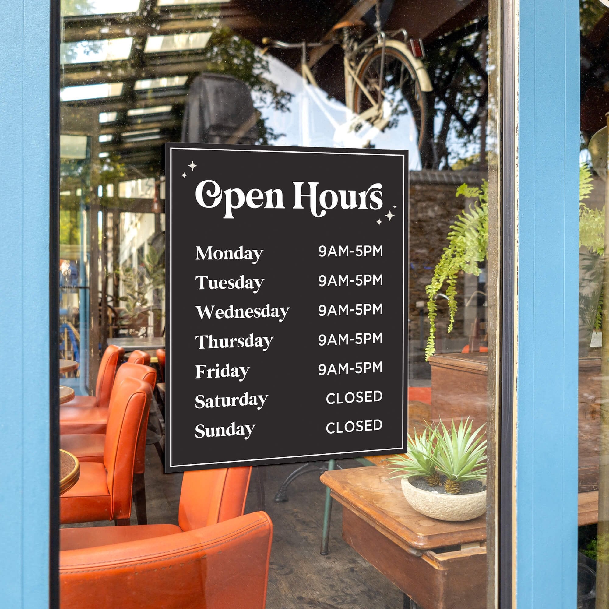 Store hours displayed on the window of a cafe