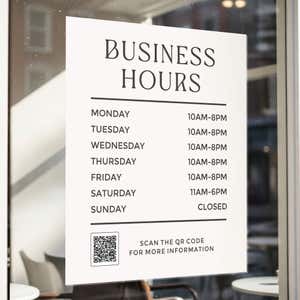 Minimalist business hours sign displayed on the window of an office