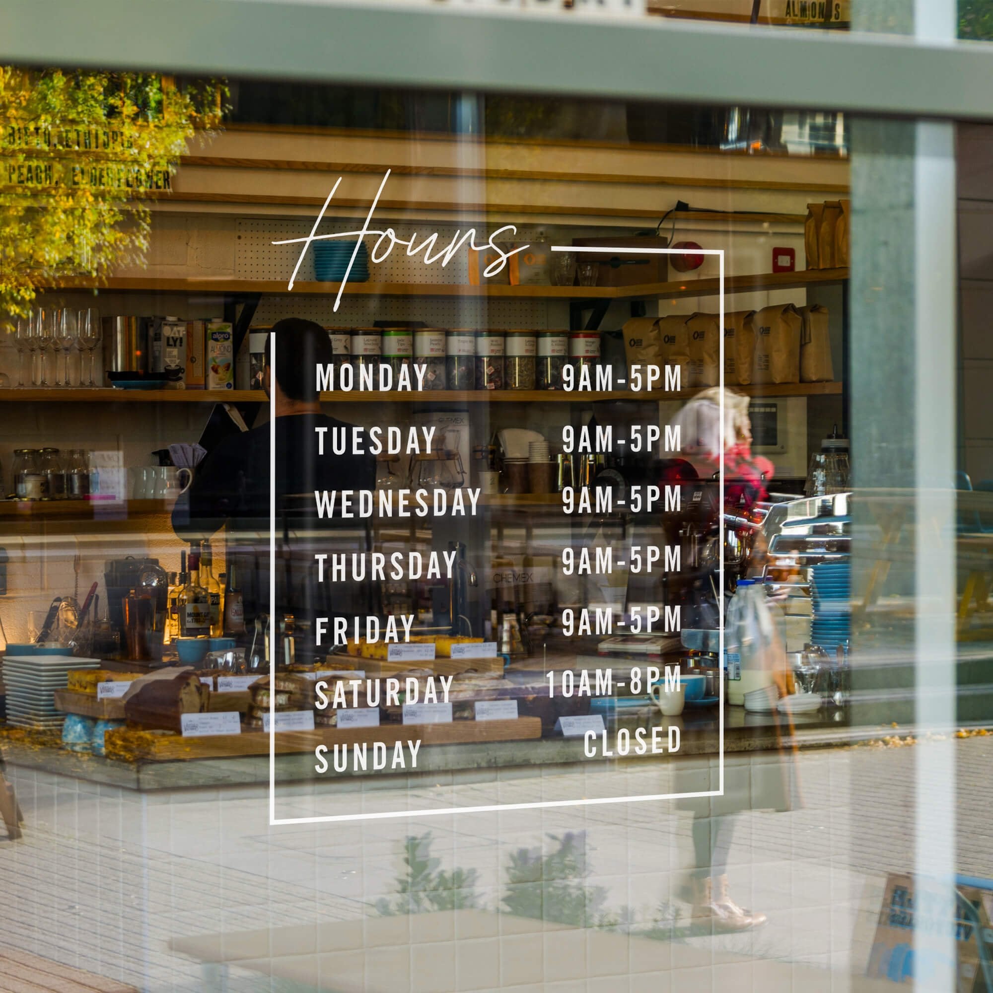 Modern business hours decal displayed on the window of a bakery