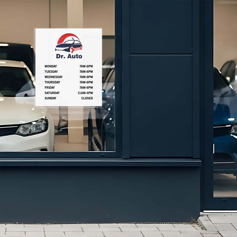 Business hours signs on a window of a car shop