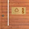 2x4 printed brass sign displayed on a wooden wall