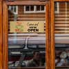 4x12 printed brass sign hanging on a glass door