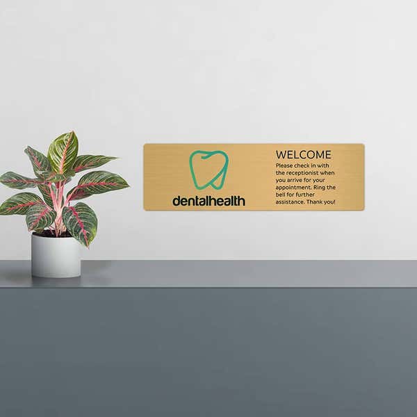 6x20 printed brass sign displayed by a front desk