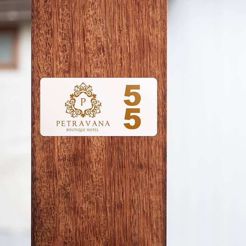 A room number sign with the hotel logo next to the number