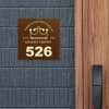A room number sign with the hotel logo on it