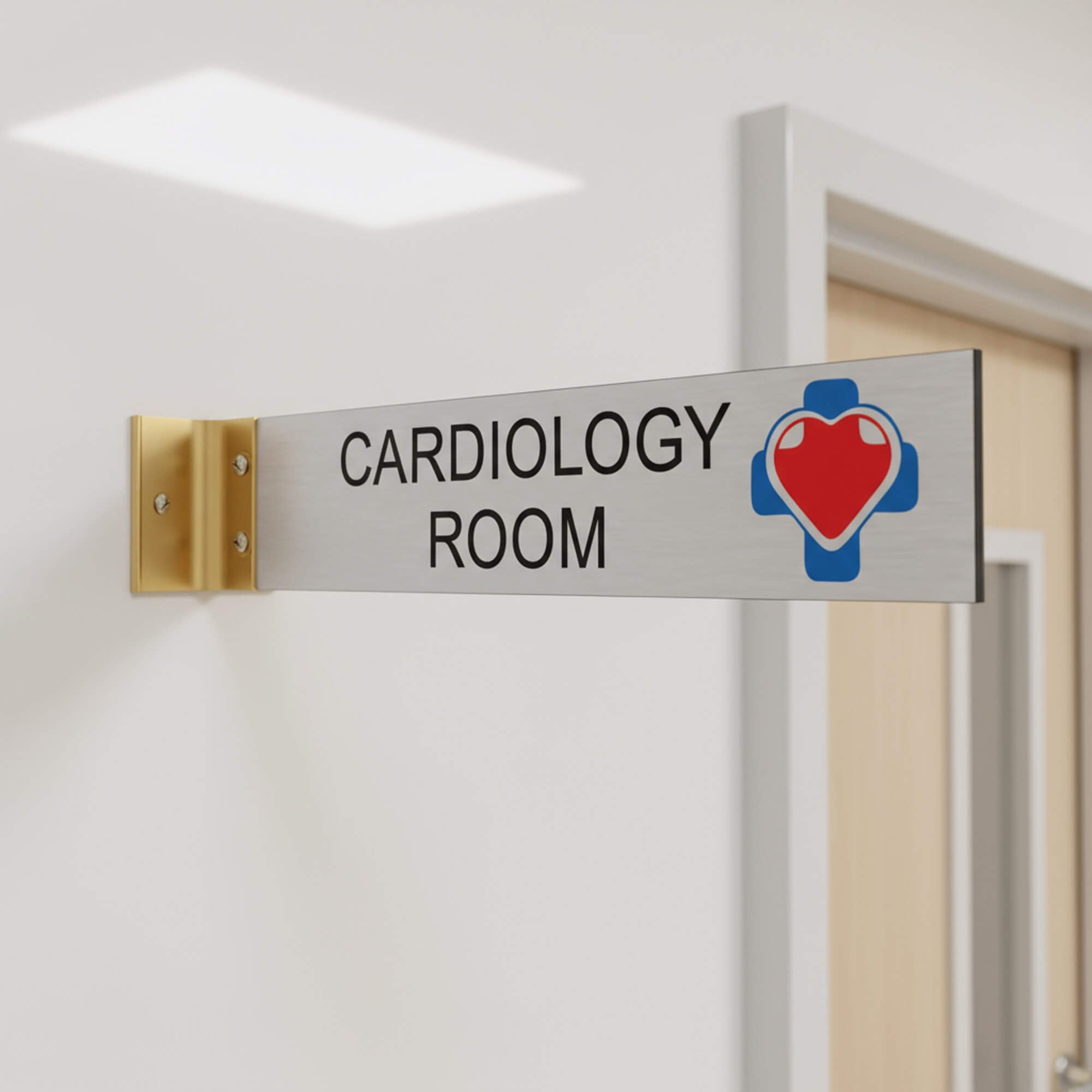 2” x 10” Corridor sign with silver material color, black engraved text, logo, and gold holder on a hallway wall with custom text saying “CARDIOLOGY ROOM”.