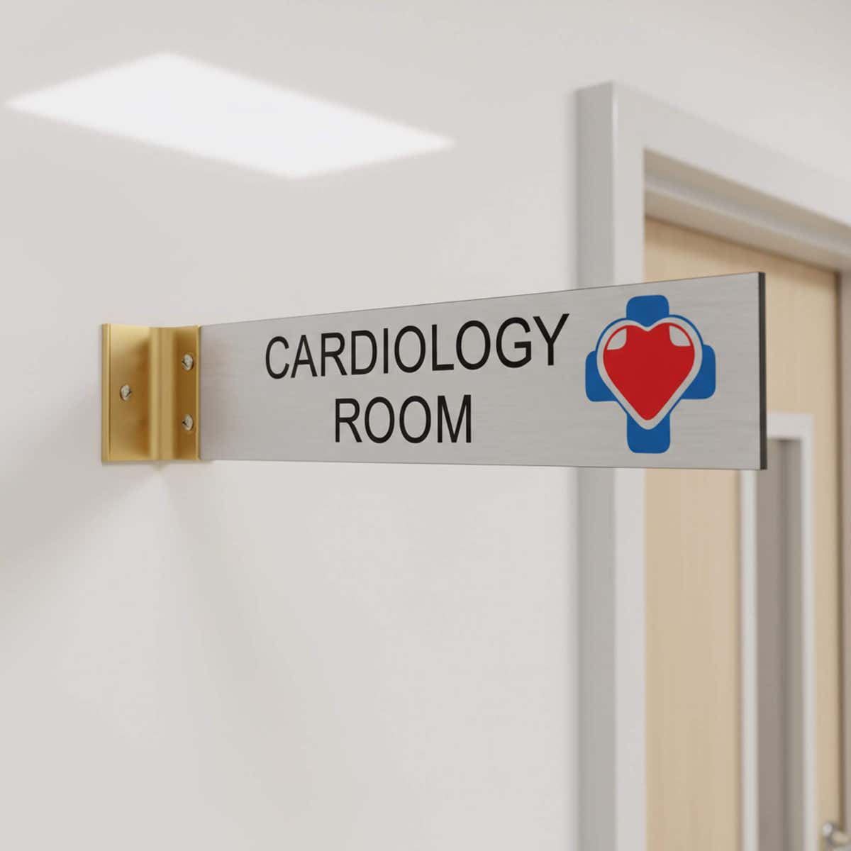 2” x 10” Corridor sign with silver material color, black engraved text, logo, and gold holder on a hallway wall with custom text saying “CARDIOLOGY ROOM”.