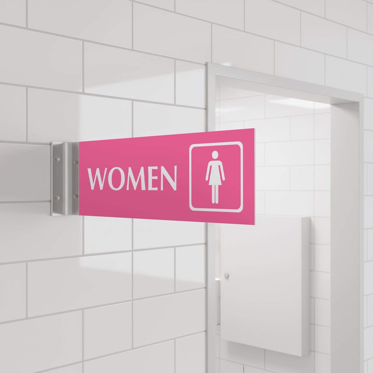 4” x 12” Corridor sign with pink material color, white engraved text, logo and silver holder on a hallway wall with text saying “WOMEN”.