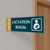 4” x 12” Corridor sign with teal material color, white engraved text, logo and gold holder on a hallway wall with text saying “LACTATION ROOM”.
