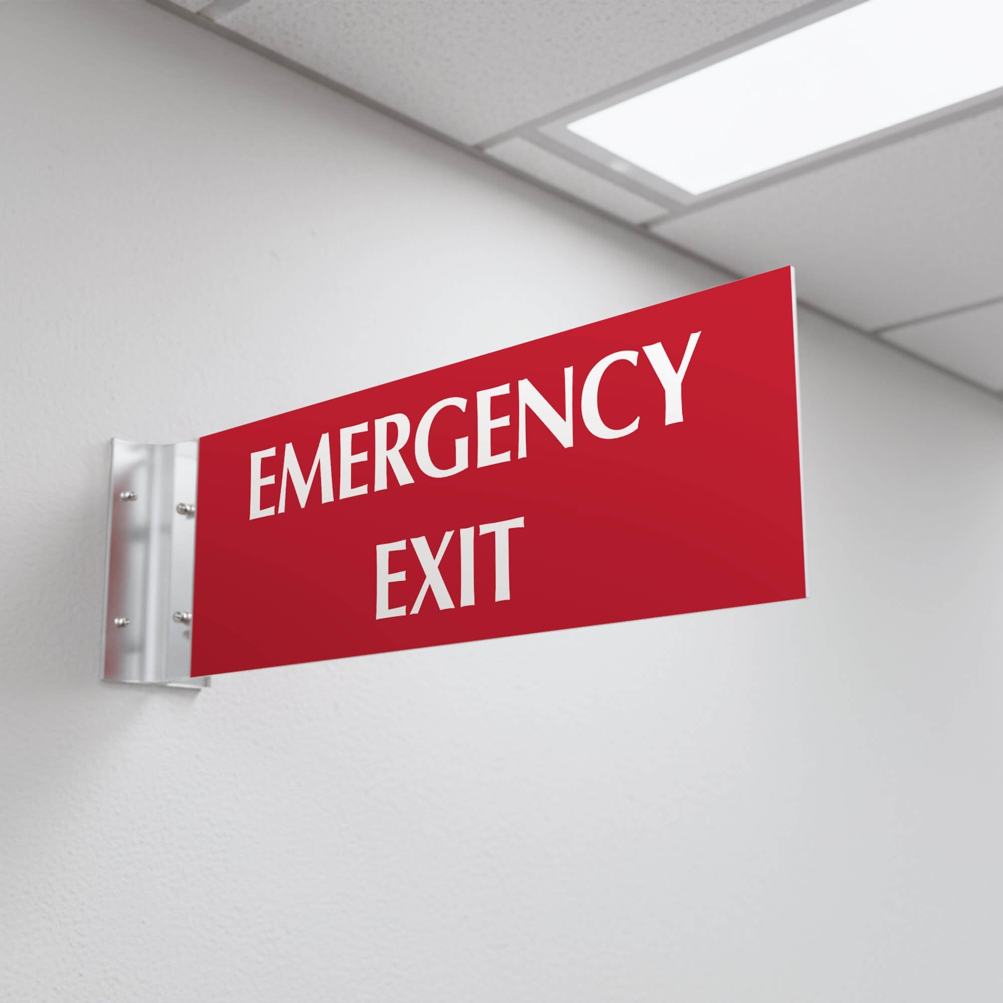 4” x 12” Corridor sign with red material color, white engraved text, and silver holder on a hallway wall with custom text saying “EMERGENCY EXIT”.