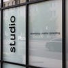 A black die-cut decal on the window of a studio