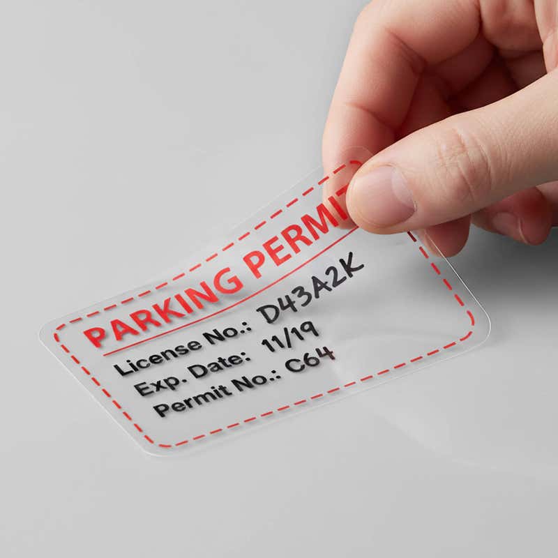 A window cling being peeled off a wall for a parking permit