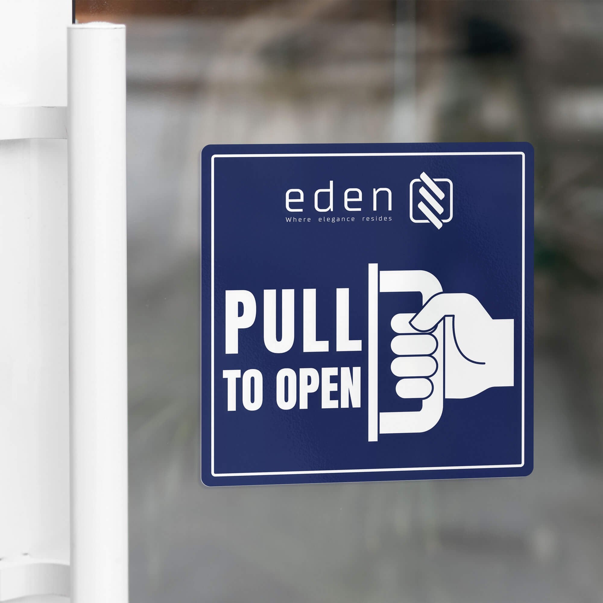 A blue window cling to pull to open on a glass door