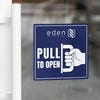 A blue window cling to pull to open on a glass door
