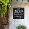 Black No soliciting. Don’t knock or ring the doorbell sign hung up on the wall.