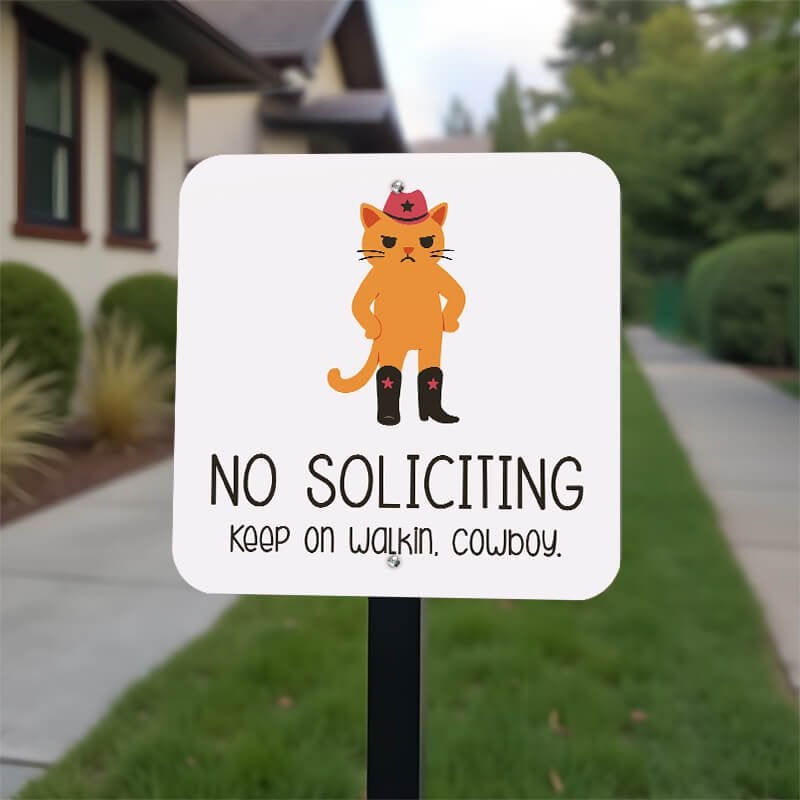 No soliciting cute cat sign reading, "keep on walking, cowboy” on a stake in the front yard