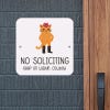Cute orange frowning cat no soliciting sign that reads, “Keep on walkin, cowboy” hung up on wall