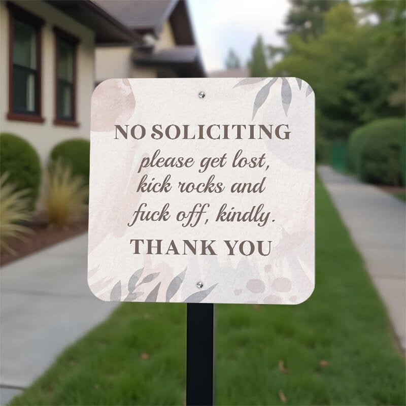 Pretty no soliciting sign on a front yard stake reading, "Please get lost, kick rocks, and f* off kindly. Thank you."