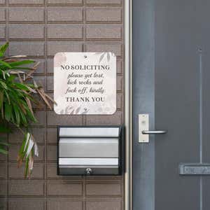 No soliciting sign hung up next to the front door reading, "Please get lost, kick rocks, and f* off kindly. Thank you."
