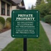 Green private property, no soliciting. loitering or trespassing sign reading Violators will be prosecuted on a yard stake