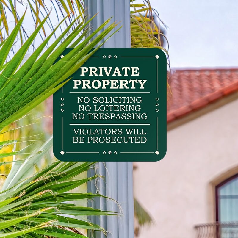 Green private property, no soliciting. loitering or trespassing sign reading Violators will be prosecuted on metal post