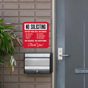 Red No soliciting sign. Do not ring bell or knock. No excuses, No exceptions in white text hung next to front door