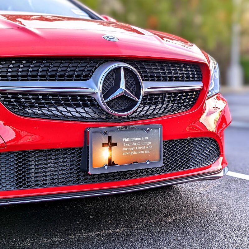 All Things Through Christ front license plate on a red car