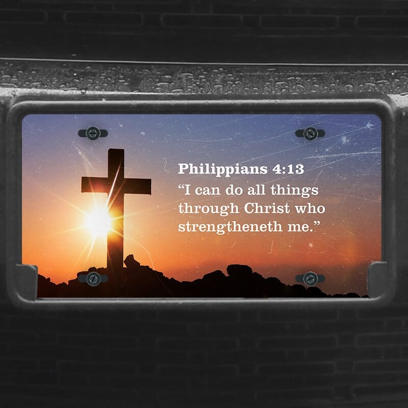 A close up of the All Things Through Christ front license plate on a black car
