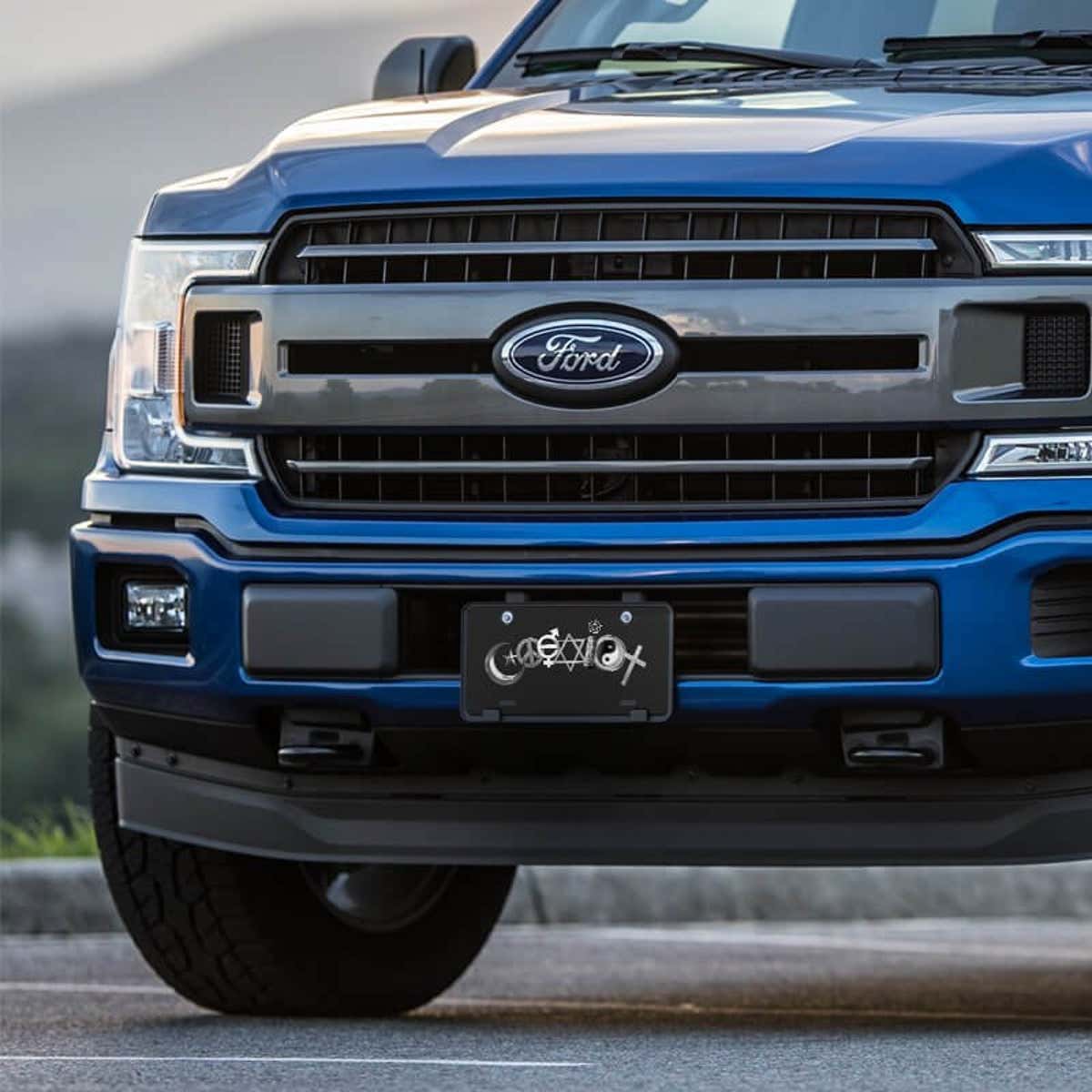 Coexist front license plate on a blue truck